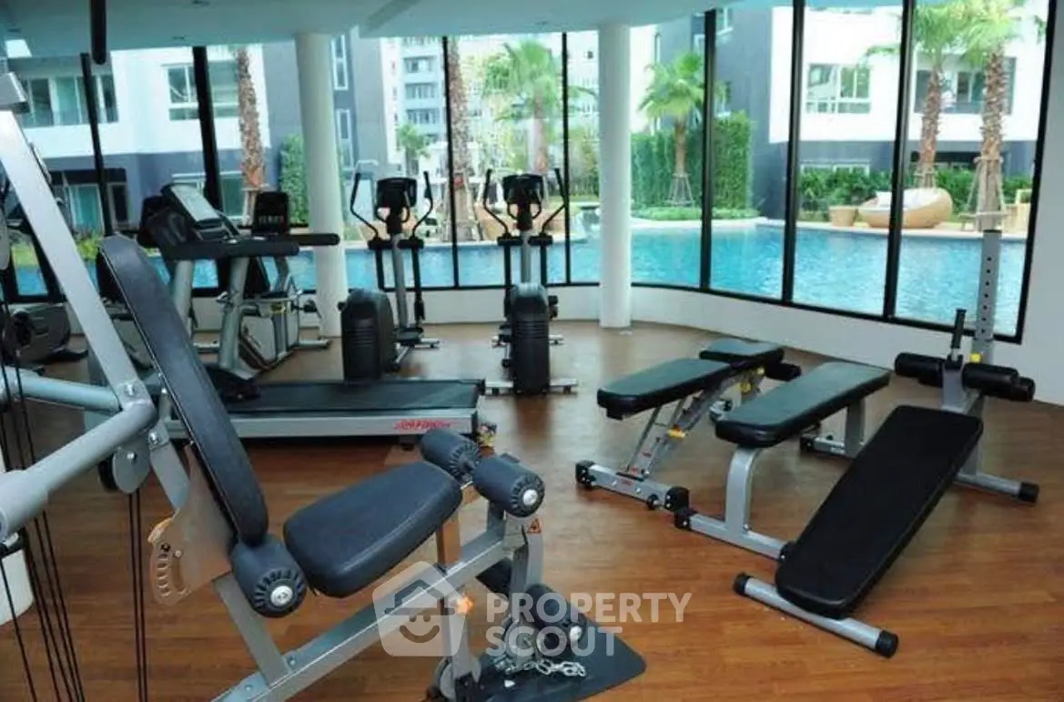 Modern gym with pool view in luxury apartment complex