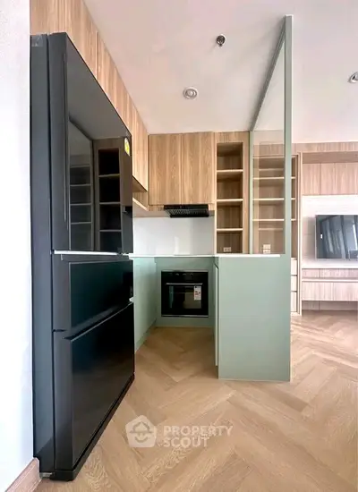 Modern kitchen with sleek appliances and stylish cabinetry in a contemporary apartment.