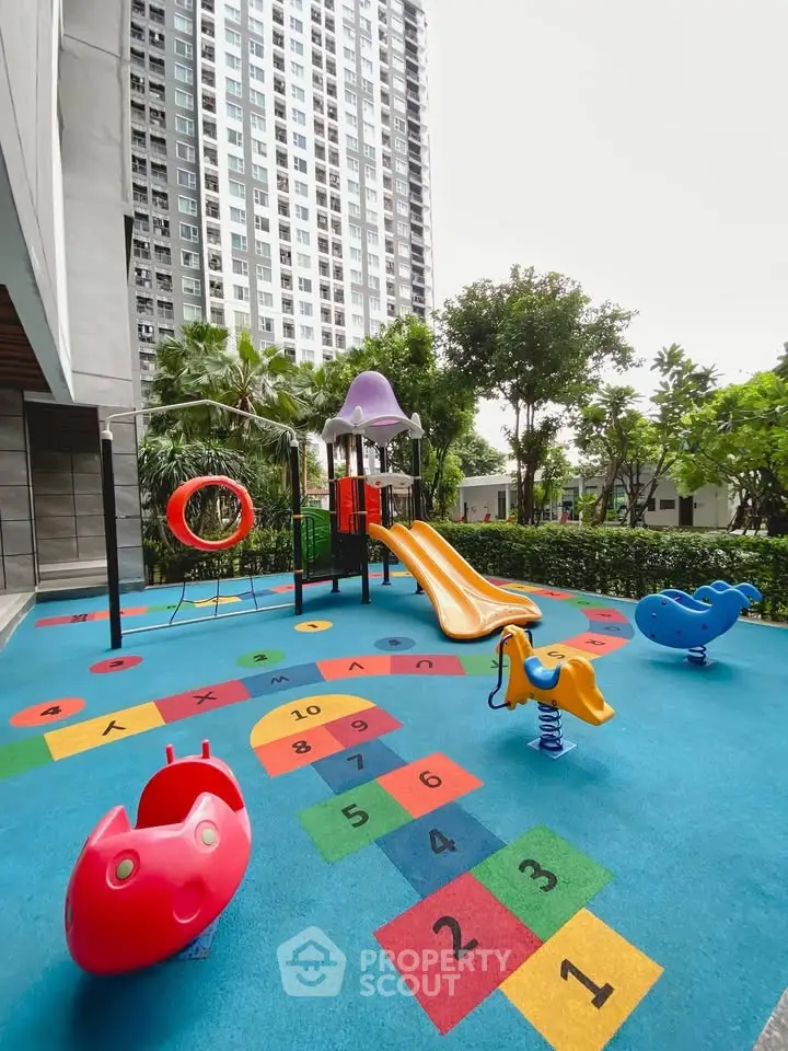 Vibrant playground area in modern residential complex with colorful slides and hopscotch.