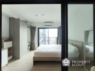 Modern bedroom with balcony access and sleek furnishings in a bright apartment.