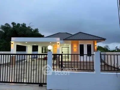 Modern single-story house with spacious driveway and elegant lighting.