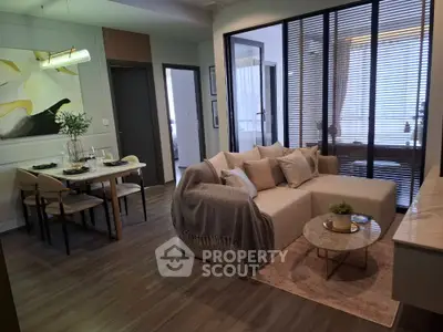 Modern living room with cozy sofa and elegant dining area in open layout apartment.