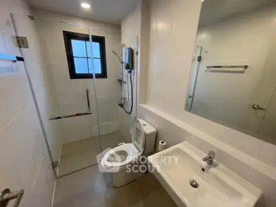 Modern bathroom with glass shower enclosure and sleek fixtures