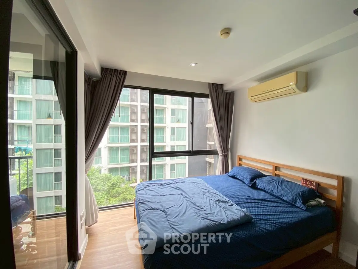 Modern bedroom with large windows and air conditioning in urban apartment
