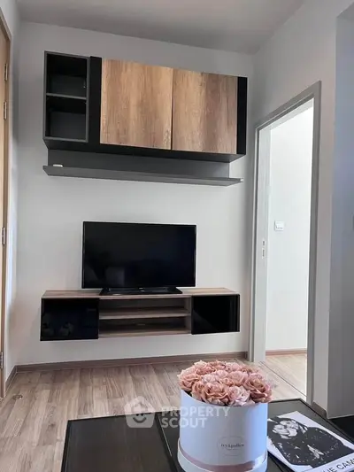 Modern living room with sleek TV unit and stylish decor in a cozy apartment.