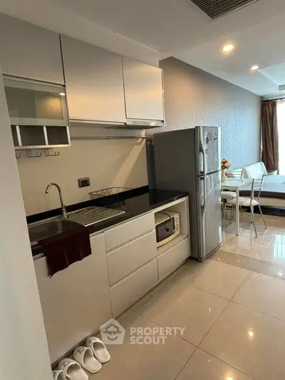 Modern kitchen with sleek cabinetry and stainless steel appliances in a stylish apartment.