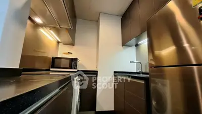 Modern kitchen with sleek cabinetry and stainless steel appliances in a compact layout.