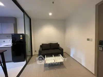 Modern living room with sleek design and compact layout, featuring a cozy sofa and stylish coffee table.