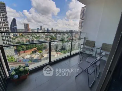 Stunning city view from a high-rise balcony with modern seating.