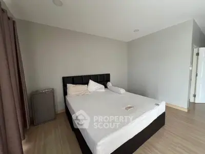 Spacious bedroom with modern decor and natural light, featuring a comfortable bed and minimalist design.