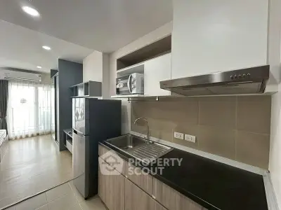 Modern kitchen with sleek cabinetry and stainless steel appliances in a stylish apartment.