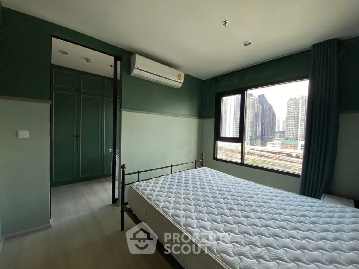 Spacious bedroom with city view and modern design in high-rise apartment