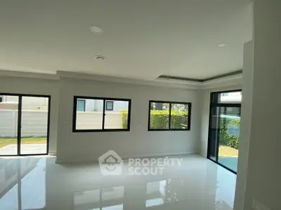 Spacious modern living room with large windows and garden view