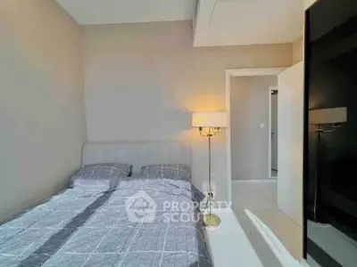 Cozy bedroom with modern decor and ample natural light, perfect for relaxation.
