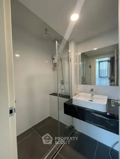 Modern bathroom with sleek shower and stylish sink in contemporary apartment.