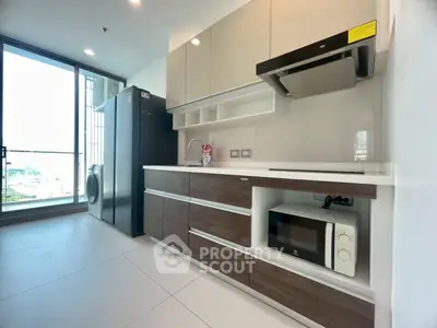 Modern kitchen with sleek cabinets, appliances, and large window view