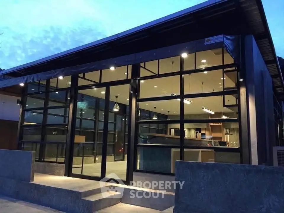 Modern industrial-style building with large glass windows and sleek design, perfect for contemporary living.