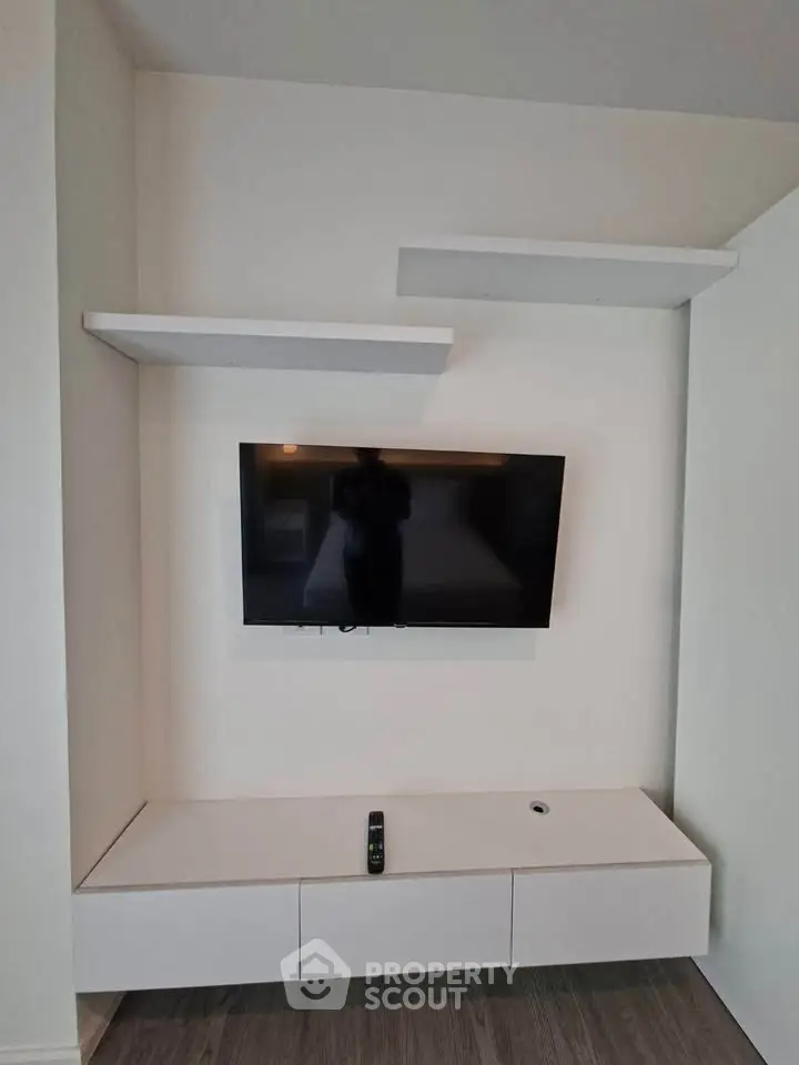 Modern living room with sleek TV setup and minimalist shelving