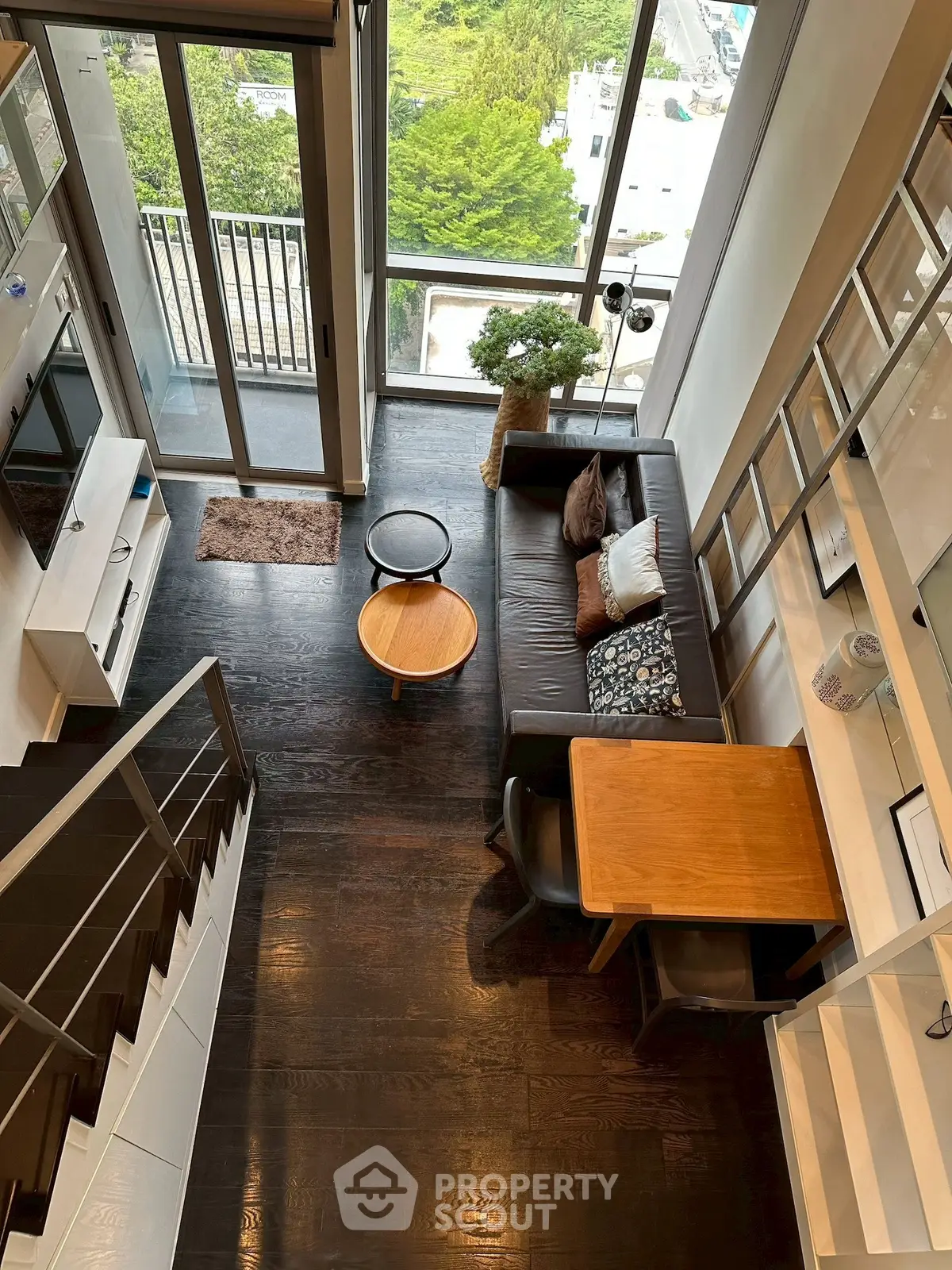 Modern loft apartment with high ceilings and large windows offering stunning city views.