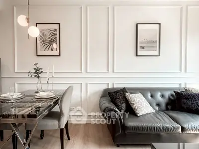 Elegant living room with chic decor, featuring a stylish sofa and modern dining area.