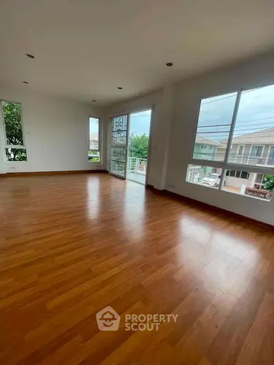 Spacious corner unit with large windows and wooden flooring, offering abundant natural light and a serene view.