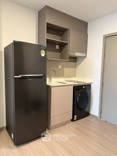 Modern compact kitchen with sleek appliances and efficient storage solutions.