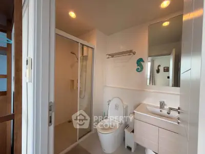 Modern bathroom with sleek fixtures and glass shower enclosure in a contemporary home.