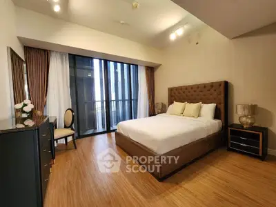 Luxurious bedroom with elegant decor and floor-to-ceiling windows in modern apartment.
