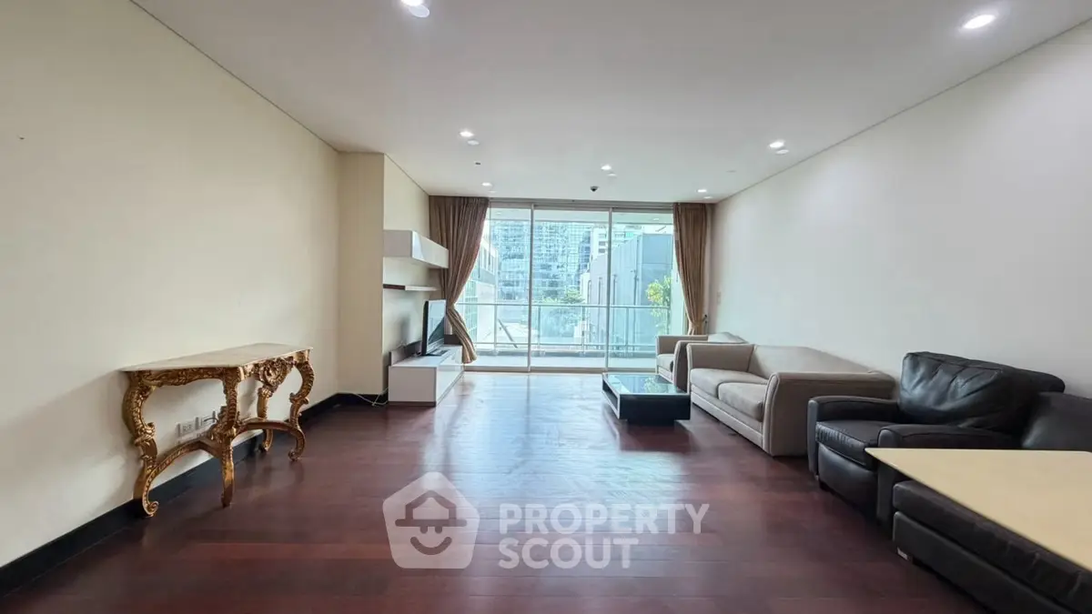 Spacious modern living room with elegant furniture and large windows offering city views.