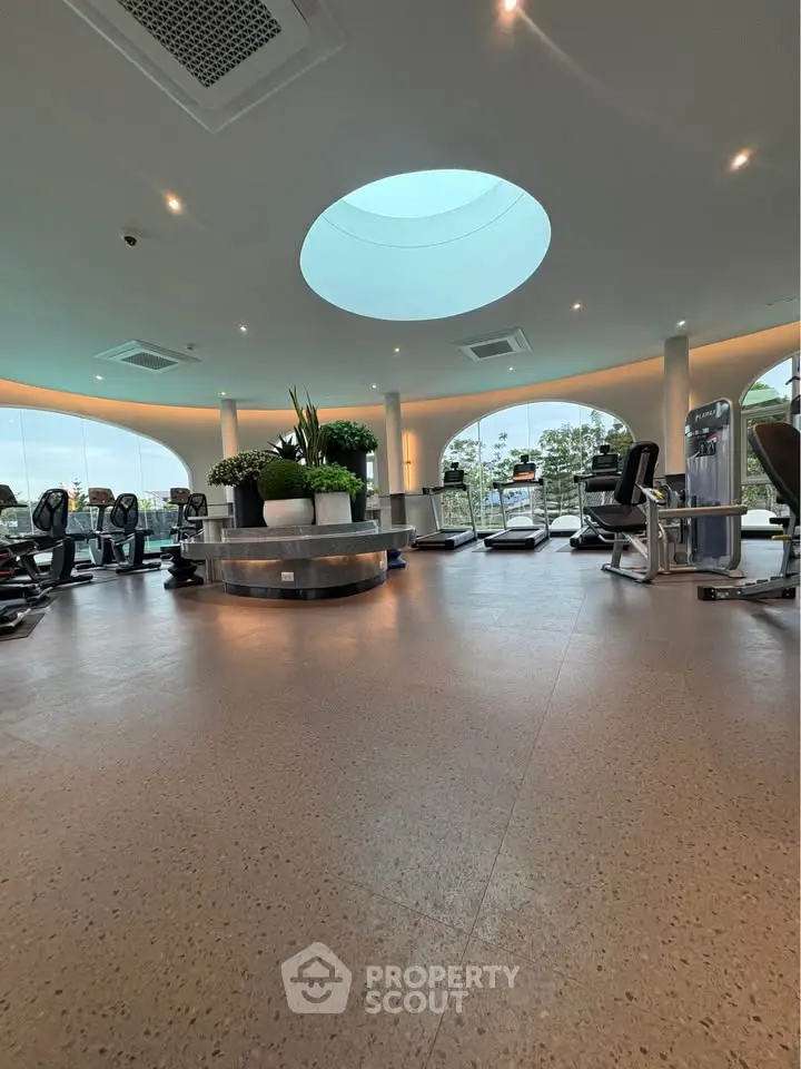 Luxurious gym with modern equipment and skylight in upscale residential building