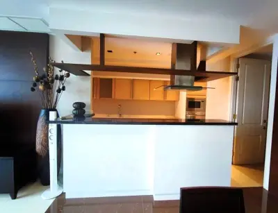 Modern kitchen with open layout and sleek design, featuring built-in oven and stylish decor.