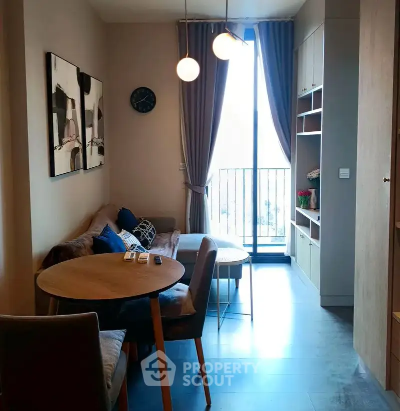 Cozy living room with modern decor and natural light from balcony window.