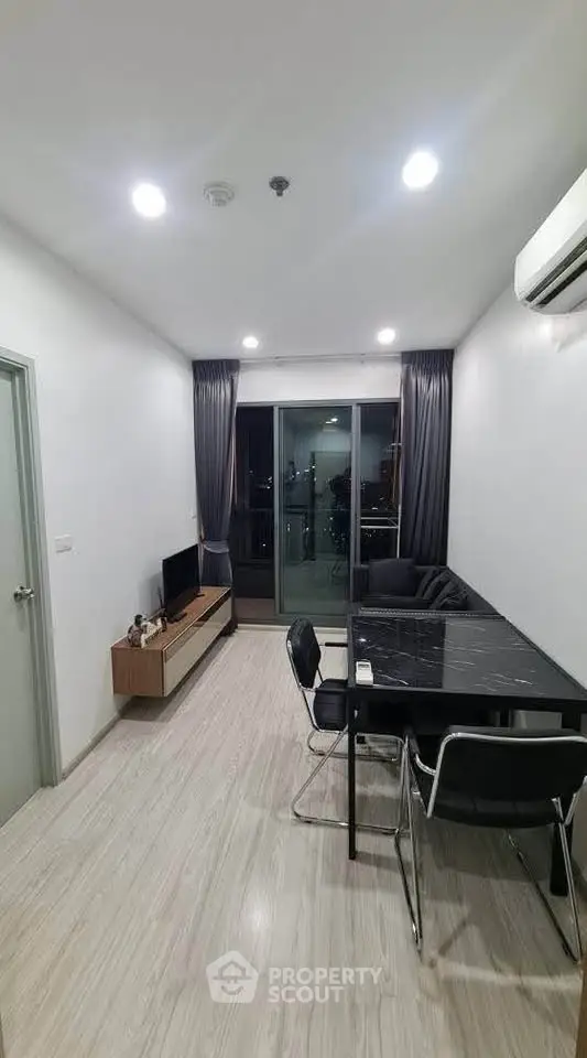 Modern living room with sleek furniture and balcony view in a stylish apartment.