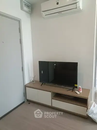 Modern living room with sleek TV setup and air conditioning unit