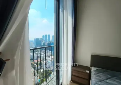 Stunning city view from modern bedroom with balcony access in high-rise apartment.