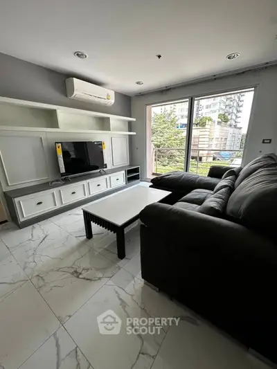 Modern living room with sleek furniture and large window offering city view