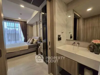 Modern bedroom with ensuite bathroom featuring sleek design and natural lighting.