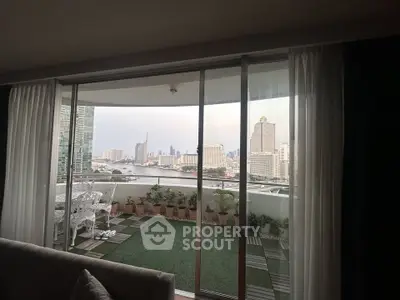 Stunning city view from a spacious balcony with elegant outdoor seating and lush greenery.