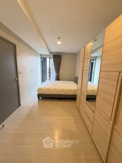 Modern bedroom with large mirrored wardrobe and balcony access