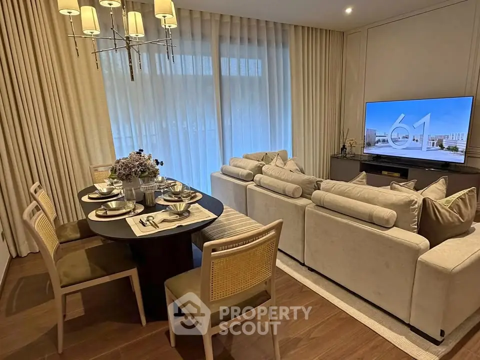 Elegant living room with dining area, featuring modern decor and a large TV, perfect for entertaining.