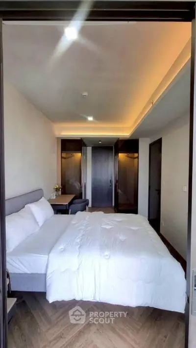 Modern bedroom with cozy bed and stylish lighting in a contemporary apartment.