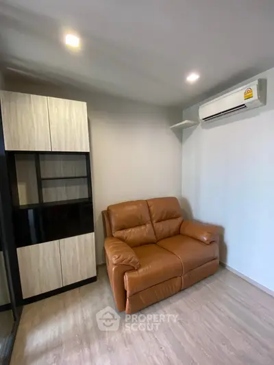 Cozy living room with leather sofa and modern storage unit, perfect for relaxation.