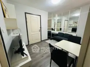 Modern living room with sleek furniture and mirrored wall for spacious feel.