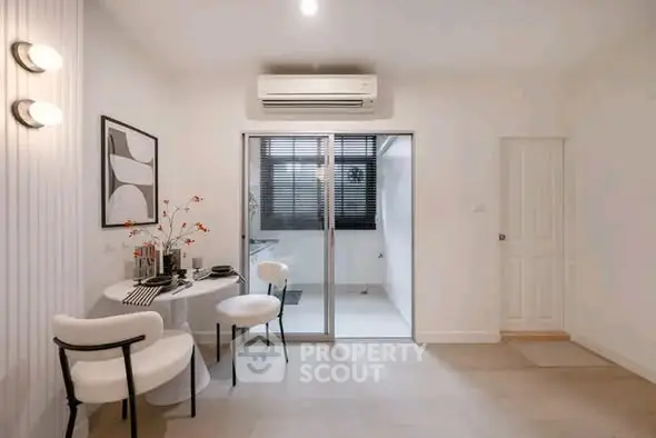 Modern dining area with stylish decor and sliding glass doors leading to a bright kitchen.