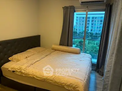 Cozy bedroom with large window offering a scenic view, featuring a comfortable bed and modern decor.
