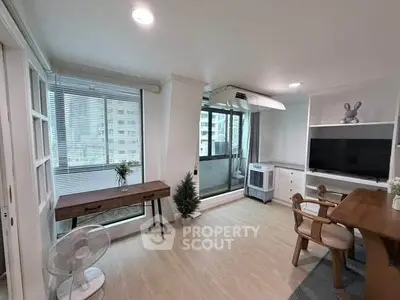 Modern living room with balcony access, featuring stylish furniture and natural light.