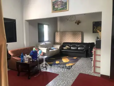 Cozy living room with eclectic furniture and decorative flooring, perfect for relaxation and gatherings.