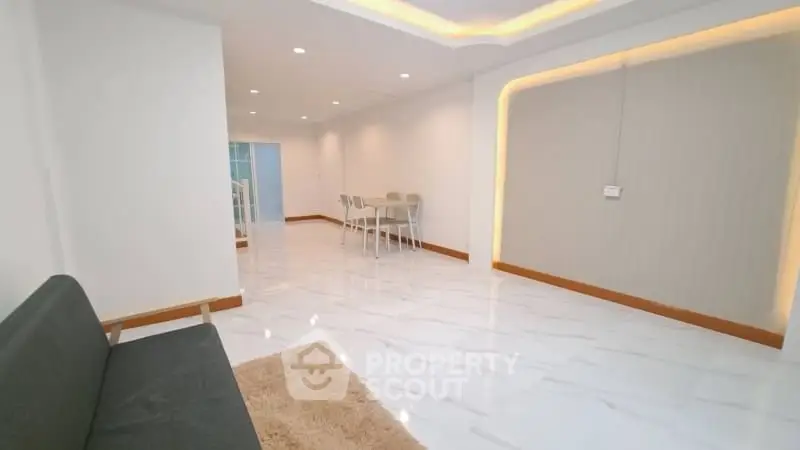 Spacious modern living room with sleek flooring and cozy seating area.