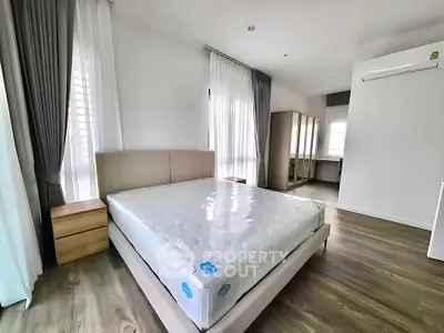 Spacious bedroom with modern design and natural light, featuring a comfortable bed and stylish furnishings.