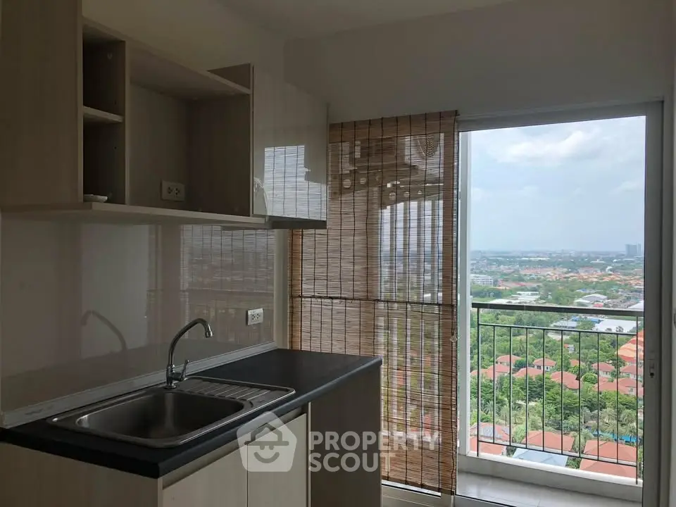 Modern kitchen with sleek cabinetry and stunning city view from balcony.